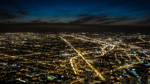 Light pollution shown in aerial nighttime view of a city and suburbs