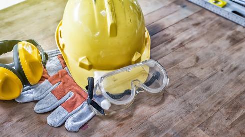 Hard hat, glasses, and gloves for construction worker safety on the job site