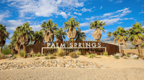 Palm Springs, California, sign with palm trees behind it