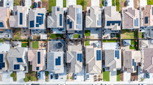 Aerial view of a row of single-family homes with solar panels on the roof