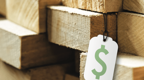 White price tag with green money symbol on stack of lumber