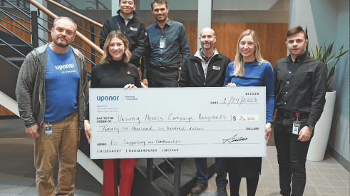Uponor Unsung Heroes campaign presents a check to employees for volunteering