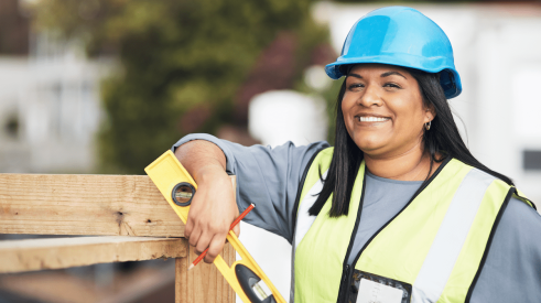 Smiling woman contractor wearing hardhat on construction site