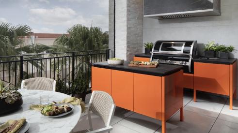 Brown Jordan outdoor kitchen cabinets in bright orange for The New American Home 2021