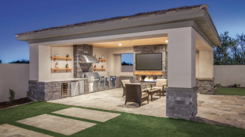 Popular features in home design include outdoor kitchens, like this one with a grill, fireplace, and comfortable seating