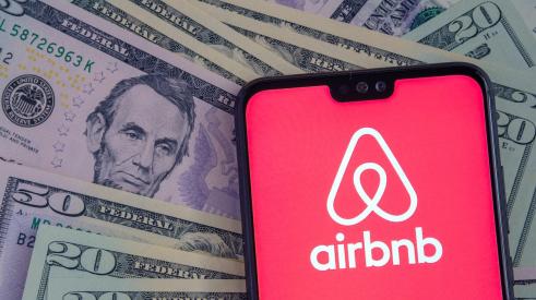 Airbnb app on phone on top of money