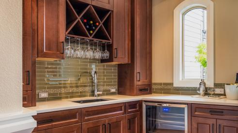 Kitchen prep area with dark wooden cabinets and wine cooler