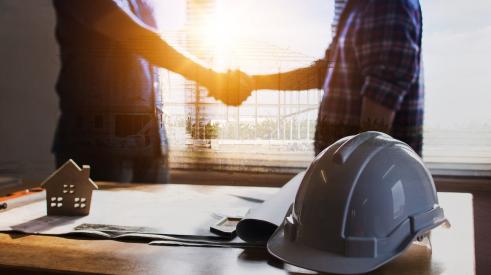 Home builder shaking client's hand after selling a new home