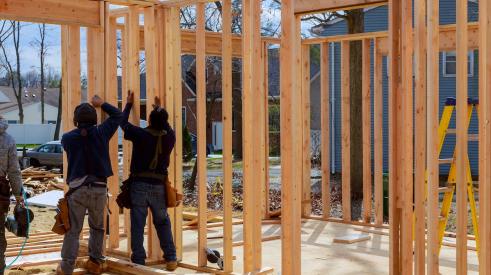 Builders framing new house with wood on jobsite
