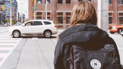 Girl_with_backpack_looking_at_car