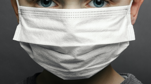Child wearing protective mask against coronavirus