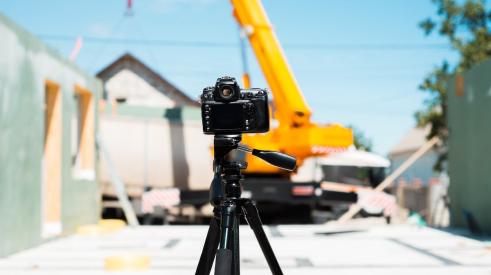 Filming video on tripod on construction site