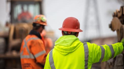 Construction worker in orange helmet and yellow vest