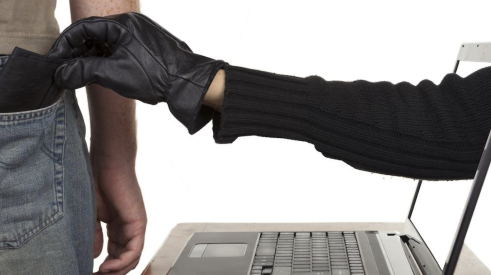 Hand of cyber criminal reaching out from laptop screen to pick-pocket