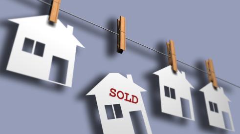 Home sold falling from clothesline holding white houses