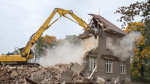Bulldozer tearing down house