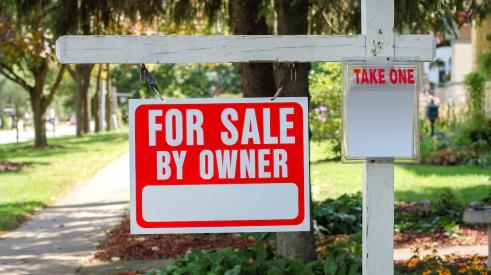 For-sale by owner sign outside of residential home