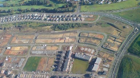 Aerial view of a housing subdivision with part complete and part still under construction.