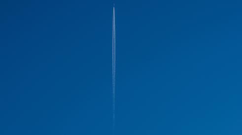 Plane flying up in blue sky
