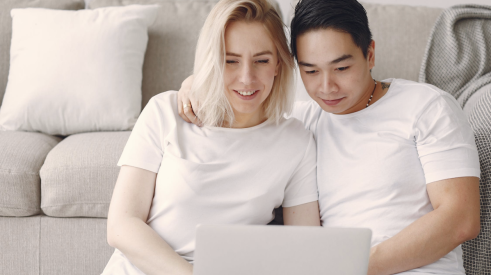 man and woman doing home buying research on laptop