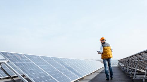 Man walking inspecting solar panels