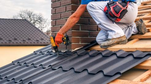 Worker fastening fire-resistant metal roof