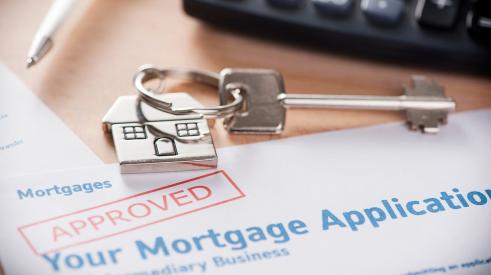 Approved stamp on mortgage application with house keys