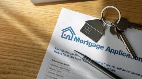 Mortgage application form and house keys on table 