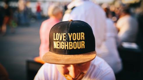 Man_wearing_Love_your_neighbor_cap