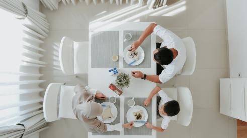 Overhead shot of family at kitchen table eating breakfast