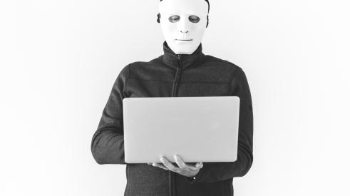 Person in mask using laptop