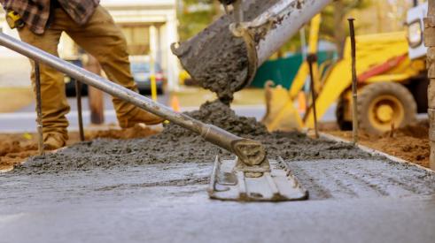 Construction workers pouring and smoothing concrete