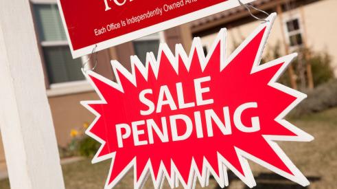 Sale pending sign under real estate sign