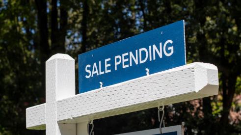 Blue sale pending sign above white for sale sign