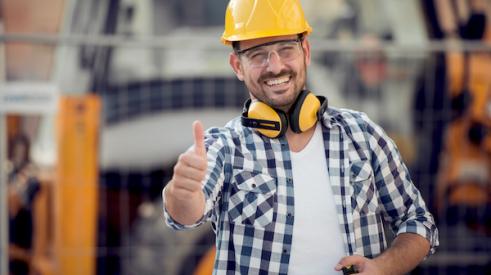 smiling builder on jobsite wearing hardhat