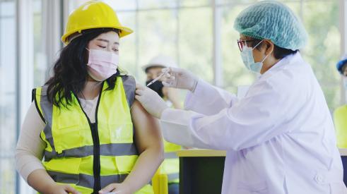 Woman construction worker getting vaccine shot