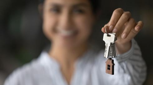 Blurred woman smiling holding silver house keys