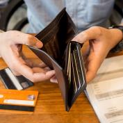 Individual looks through wallet while going over bills