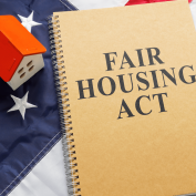 Fair Housing Act and model of a house with the American flag in the background