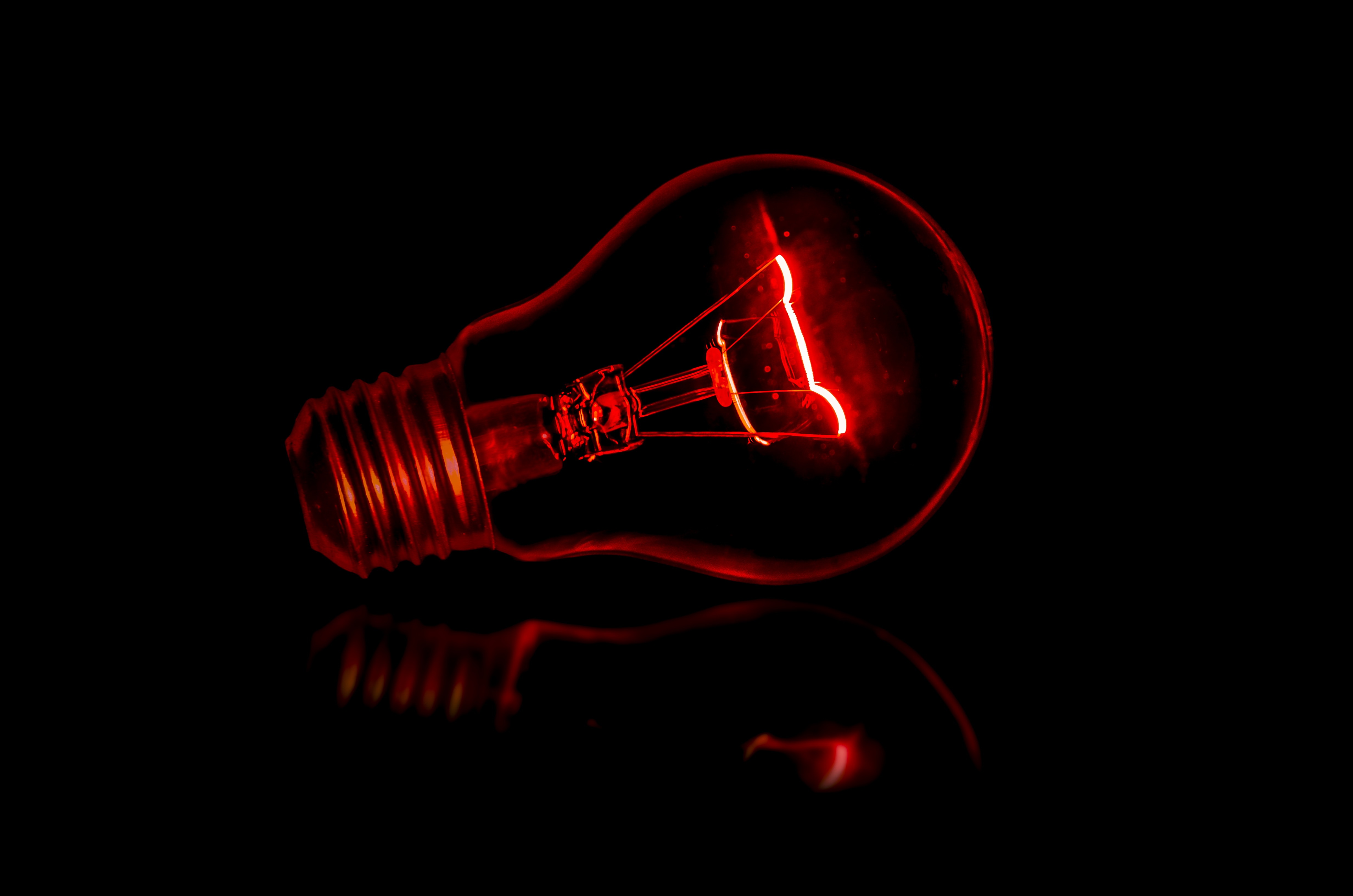 Red light bulb against black background