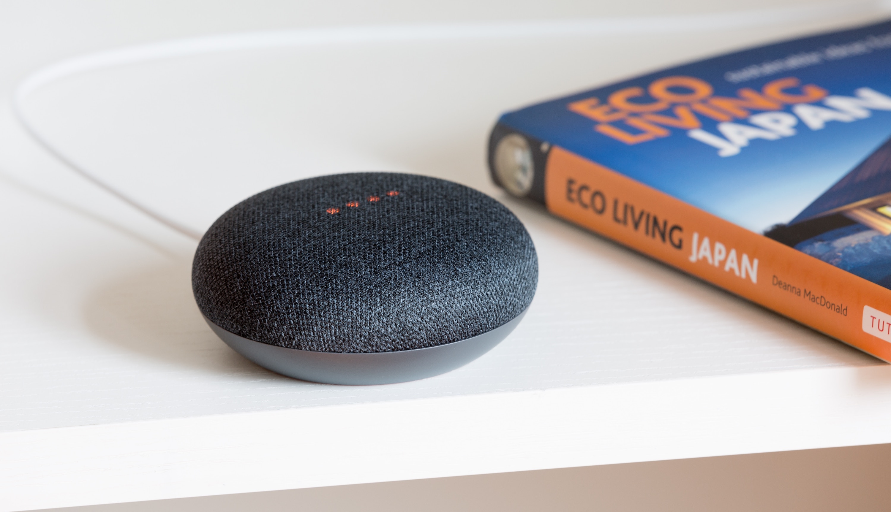 Google Home Assistant on a table with a book