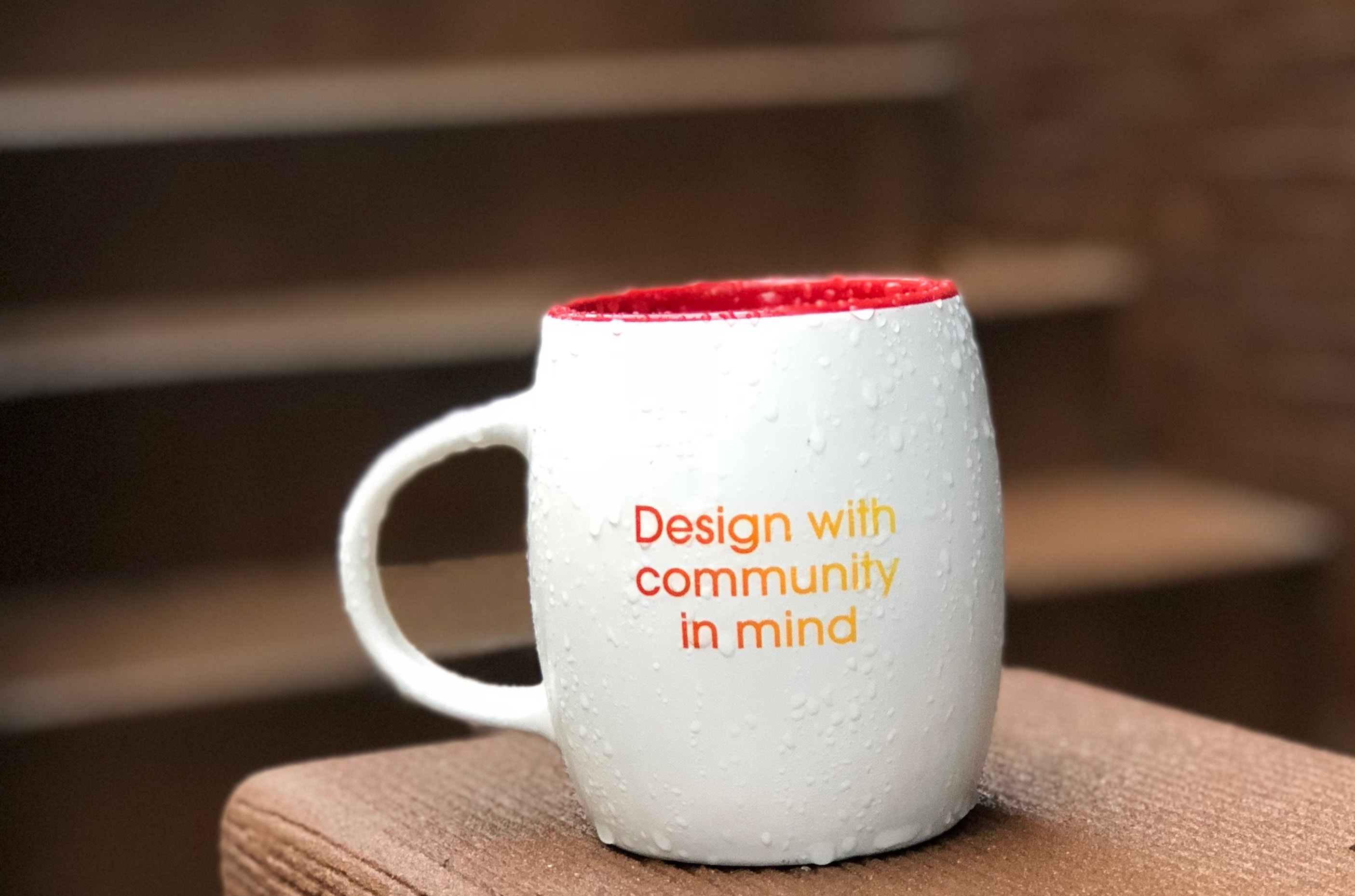 Mug that says "design with community in mind"