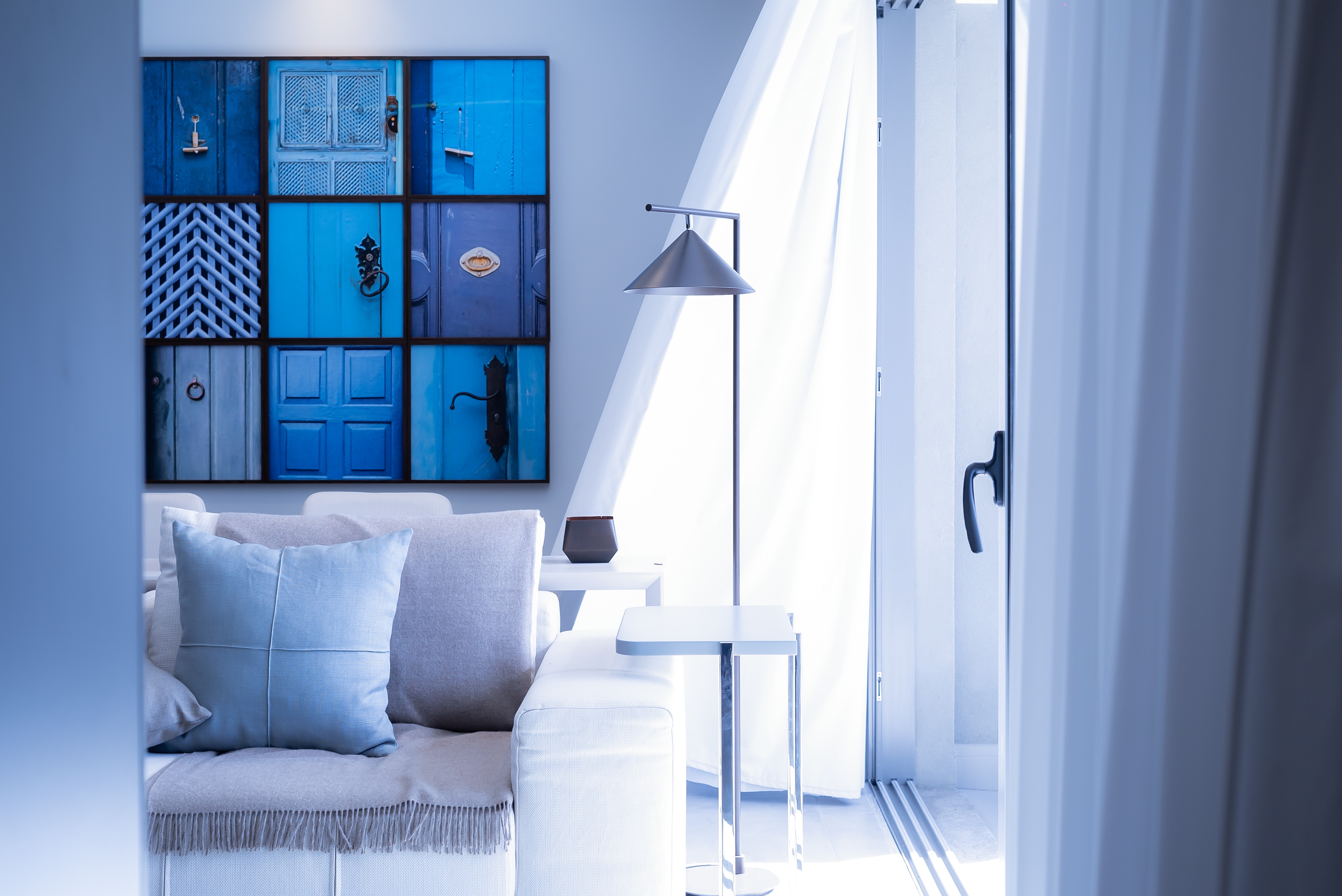 House interior with lamp sofa and blue wall hanging