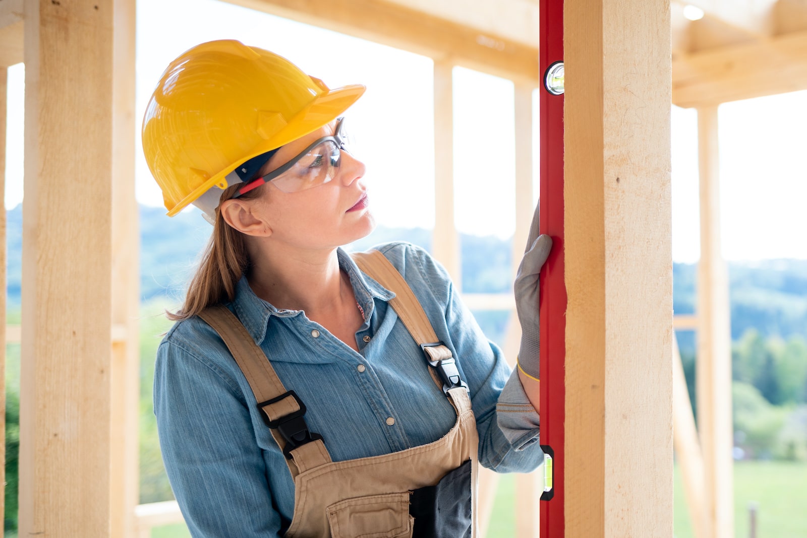 Women with hard hat and carpeter's level