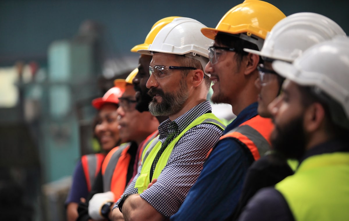 Row of construction workers wearing hard hats and vests