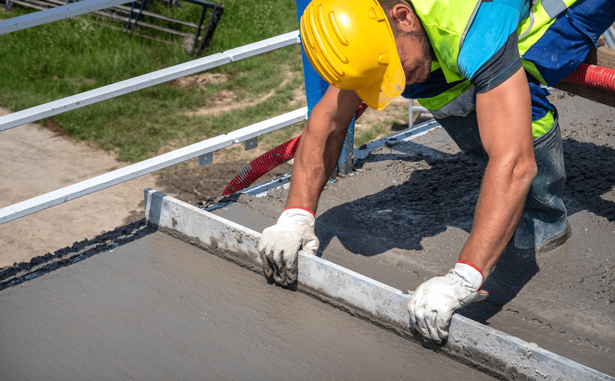 Construction worker leveling concrete on jobsite
