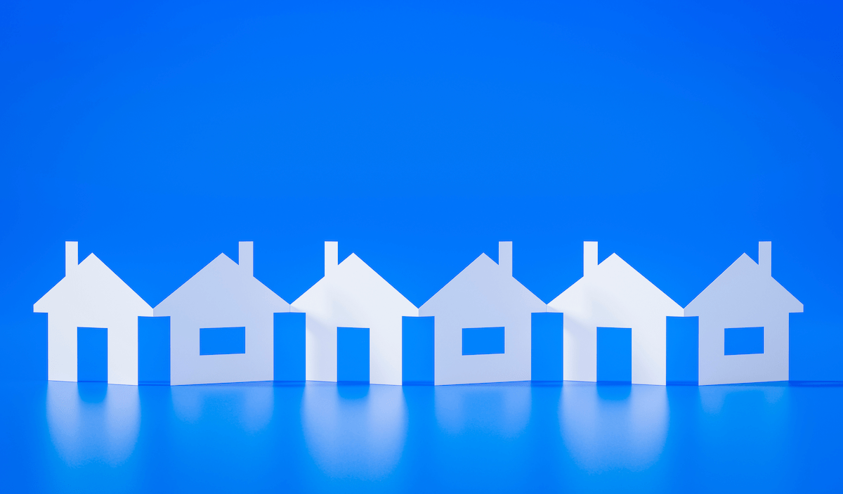 Row of white paper cutout houses