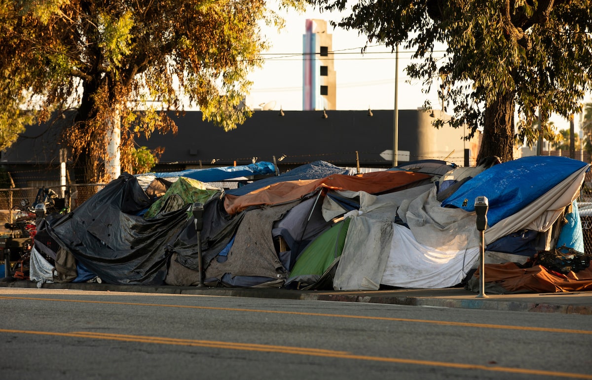 Tents crowded by the road in a homeless encampment