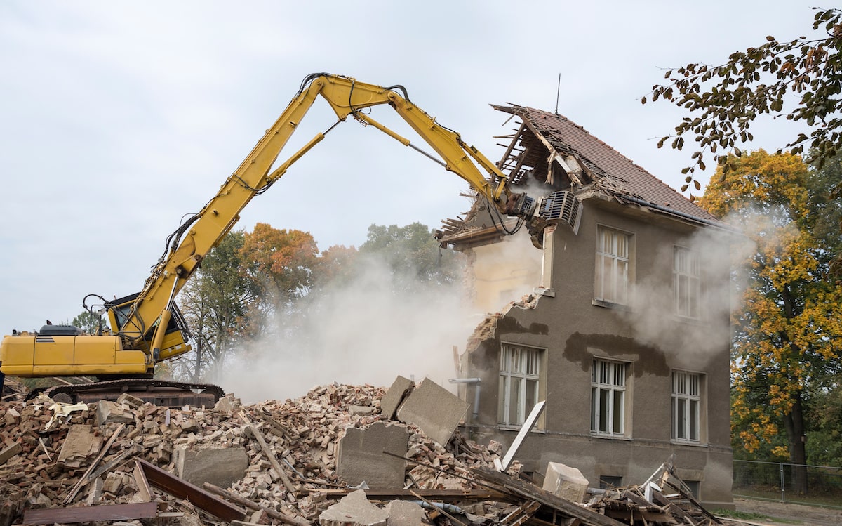 Bulldozer tearing down house