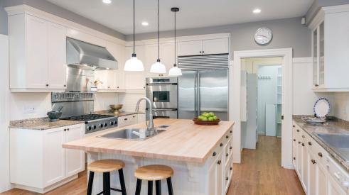 Modern white kitchen with central island and stainless steel appliances